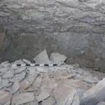 View of the inside of an Egyptian tomb. Rock and rubble are scattered all around.