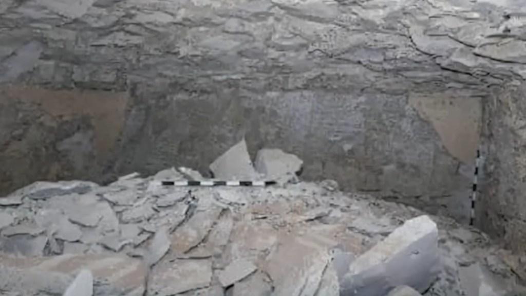 View of the inside of an Egyptian tomb. Rock and rubble are scattered all around.