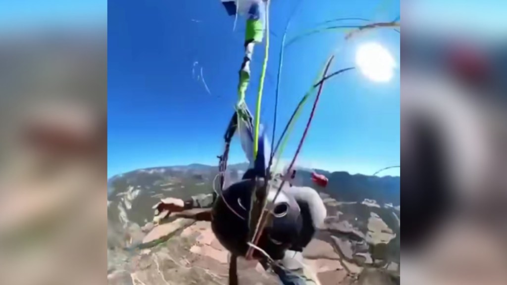 Close view of a skydiver as he tries to untangle his parachute while falling from the sky